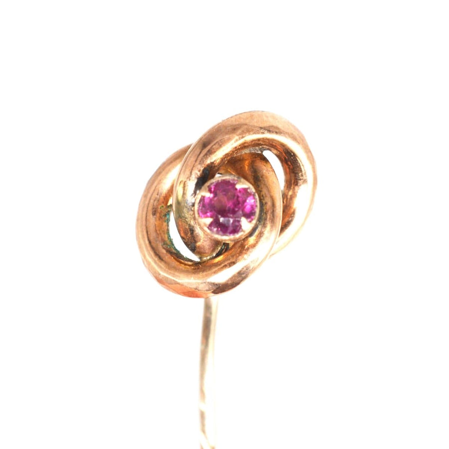 Victorian gold knot tie pin circa 1880s with garnet, symbolizing the lover's knot, elegant accessory for men.