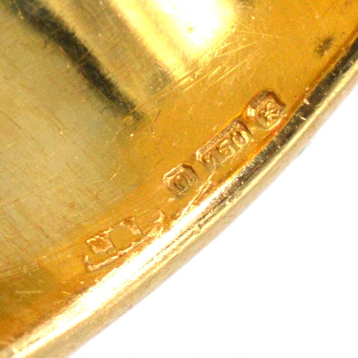 Close-up of a vintage 18ct gold hallmark on a band ring, showcasing quality and authenticity.