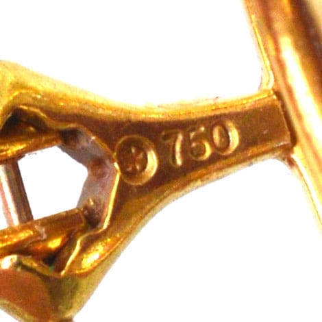 Close-up of 750 gold hallmark indicating 18ct purity on vintage earrings.