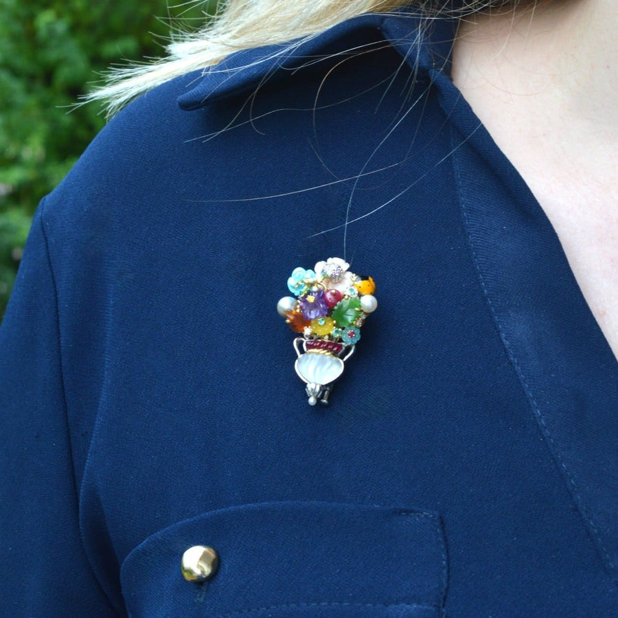 Vintage 18ct white gold multi-gem Giardinetto brooch by Santagostino on navy shirt, featuring colorful flowers and a rock crystal vase.
