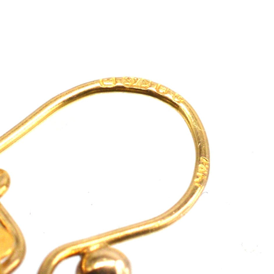 Close-up of a 9ct gold earring hook showcasing intricate craftsmanship and hallmark from the 1970s.
