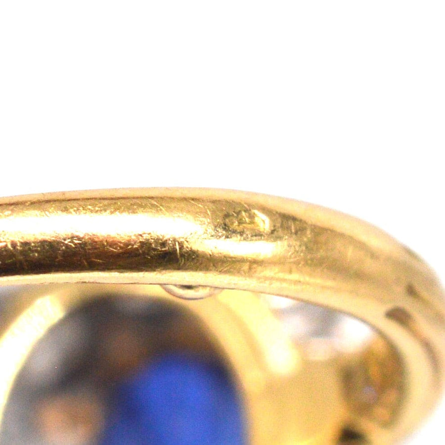 Close-up of the elegant 18ct gold shank of a vintage 1960s sapphire and diamond cluster ring.