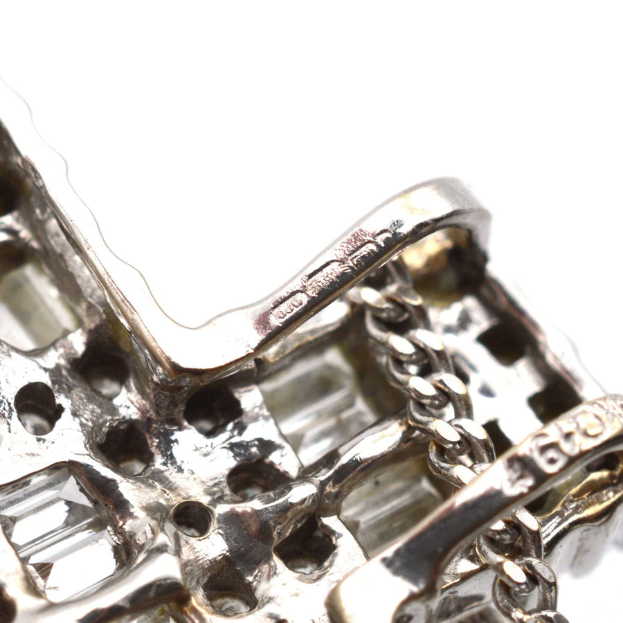 Close-up of vintage 1990s 18ct white gold cross pendant showcasing diamond detailing and chain link.