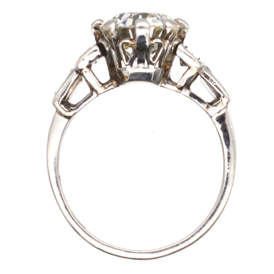 Large Art Deco platinum diamond solitaire ring featuring a 2.3 carat Old European cut diamond and baguette shoulders.