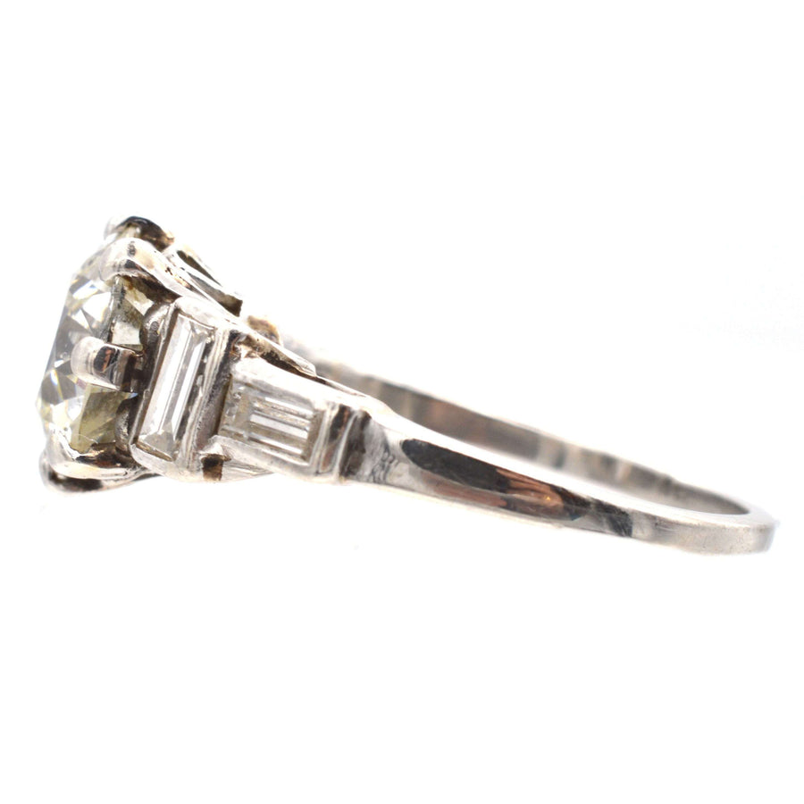 Large Art Deco platinum ring featuring a 2.3 carat old European cut diamond and baguette diamond shoulders.