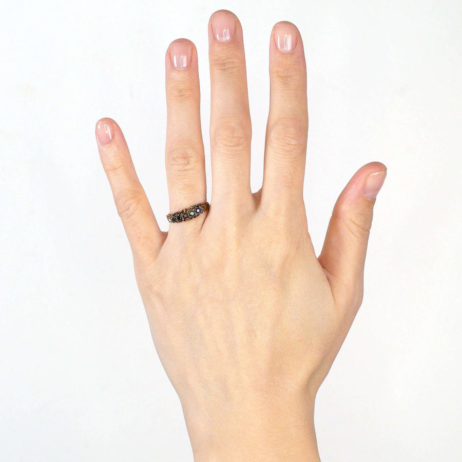 Victorian 15ct gold acrostic ring with gemstones spelling 'Dearest' worn on a hand.