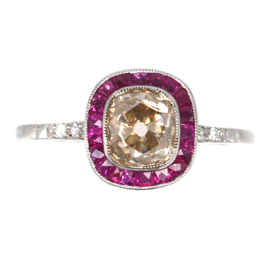 Art Deco platinum engagement ring featuring a 1.3 carat champagne diamond surrounded by ruby stones.
