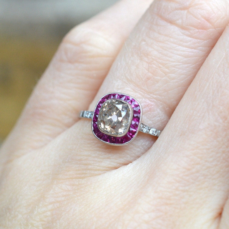 Art Deco platinum ring featuring a 1.3 carat champagne diamond and rubies, showcasing an elegant vintage design.