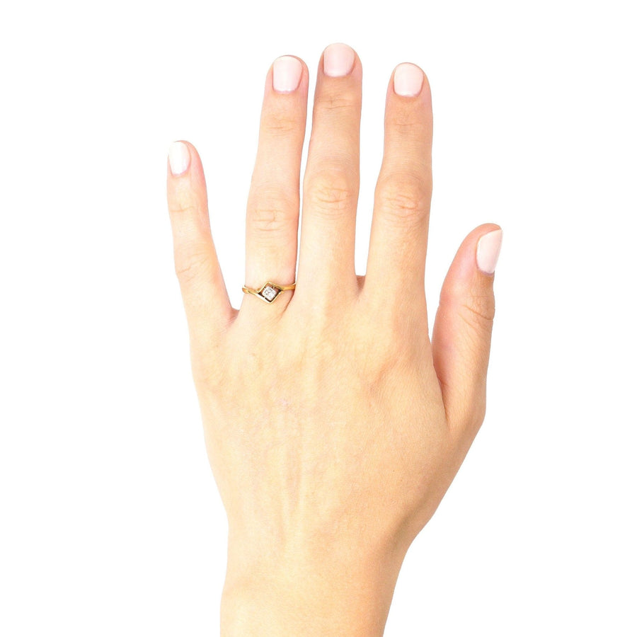 Art Deco 18ct gold and diamond solitaire twist ring displayed on a hand, showcasing its elegant design.