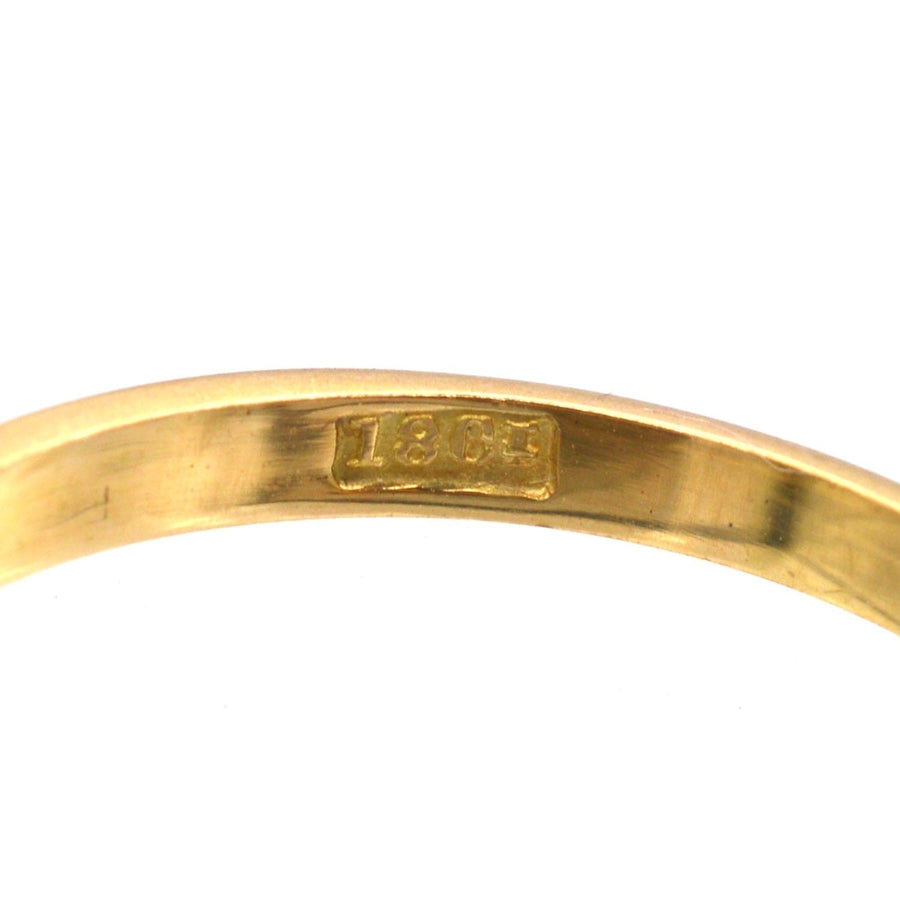 Close-up of the inner band of an 18ct gold ring showing the hallmark from the 1920s.