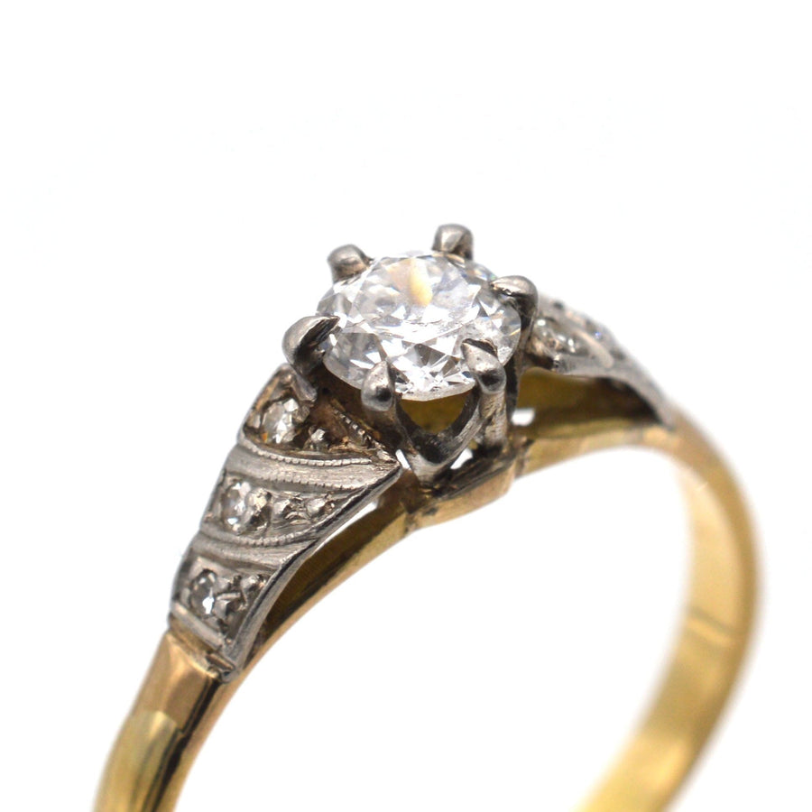 Art Deco 18ct gold diamond solitaire ring with sparkling center diamond and decorative side diamonds.