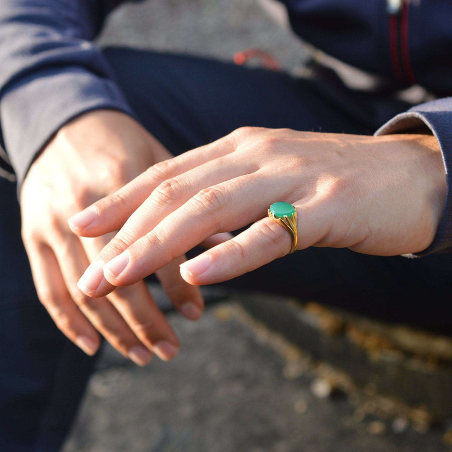 Art Deco 18ct gold signet ring with green chalcedony worn on a person's hand.