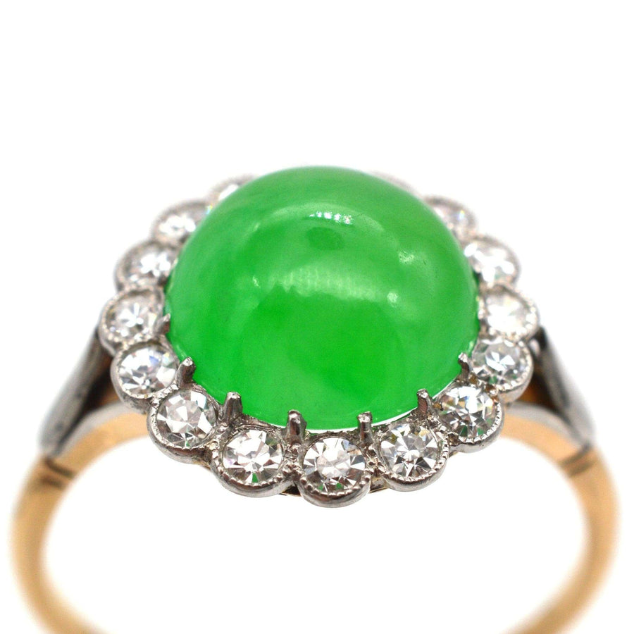 Art Deco 18ct gold ring featuring Grade A imperial jade and diamond cluster, showcasing a vibrant green cabochon stone.