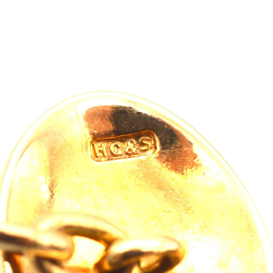 Close-up of hallmark on Art Deco 18ct gold cufflinks by Henry Griffith & Sons, indicating quality and craftsmanship.