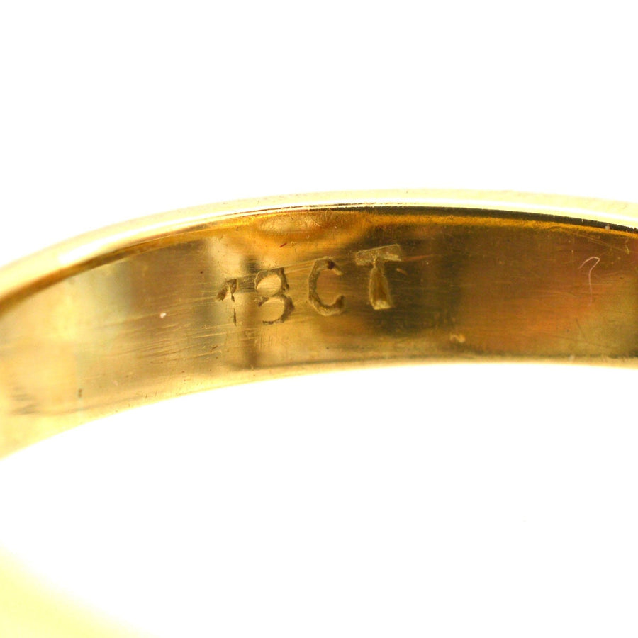 Close-up of the inner band of an Art Deco ring, featuring '18CT' inscription indicating gold purity.