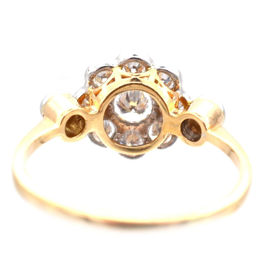 Art Deco 18ct gold and platinum diamond cluster ring featuring eight diamonds surrounding a central stone.