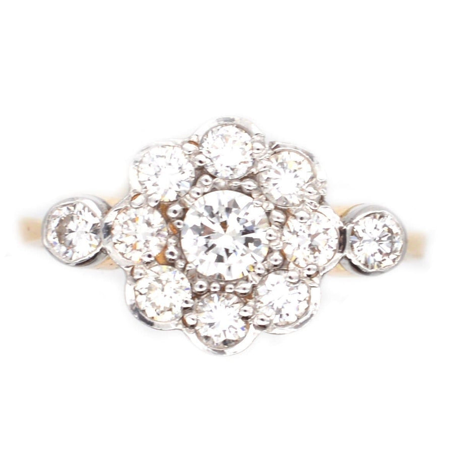 Art Deco diamond cluster ring in 18ct gold and platinum with a central diamond and surrounding stones, elegant design.