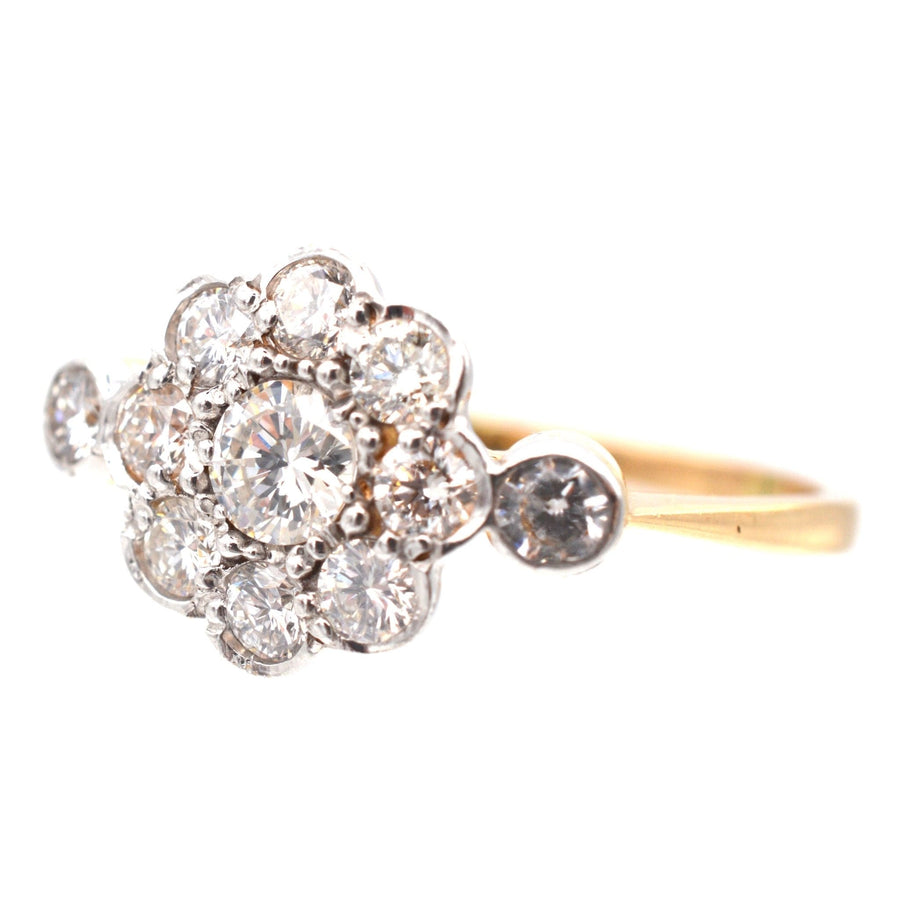Art Deco diamond cluster ring in 18ct gold and platinum, featuring eight diamonds encircling a larger central diamond.