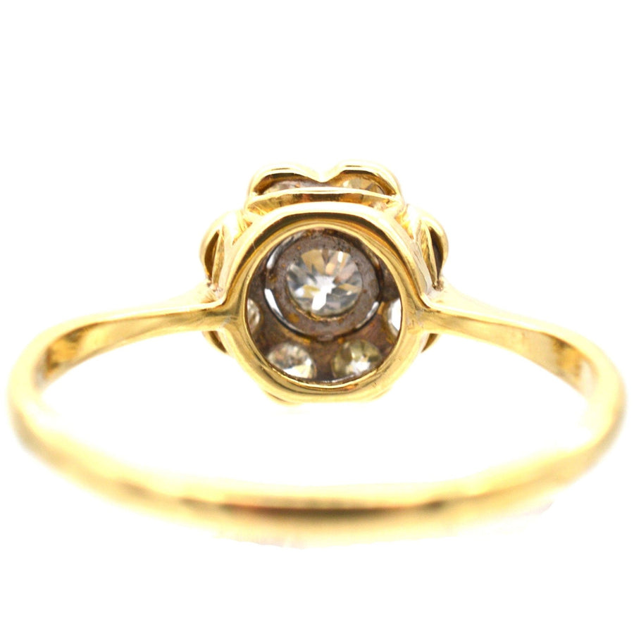 Art Deco 18ct gold and platinum diamond cluster ring featuring a central diamond and exquisite millegrain setting.