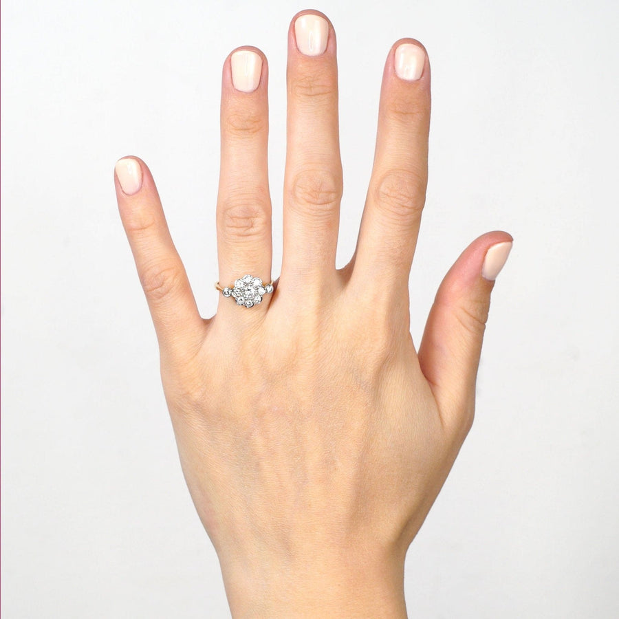 Art Deco 18ct gold and platinum diamond cluster ring displayed on a hand, showcasing elegance and comfort.