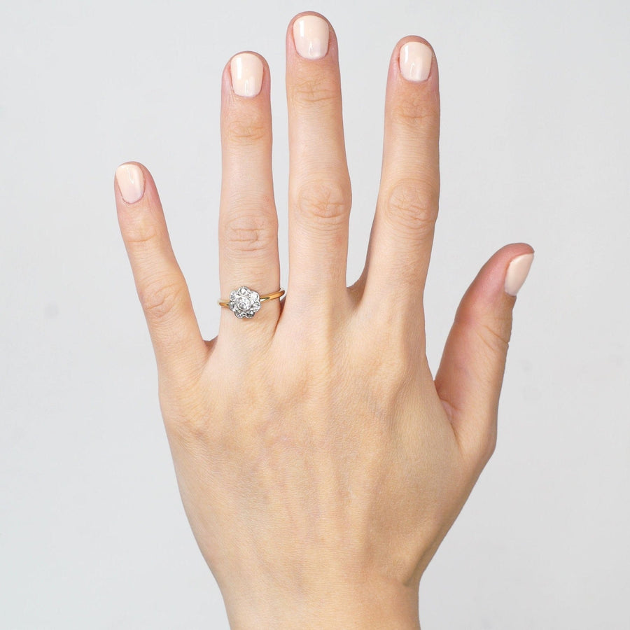 Art Deco 18ct gold and platinum diamond cluster ring worn on a woman's hand, showcasing its elegance and sparkle.