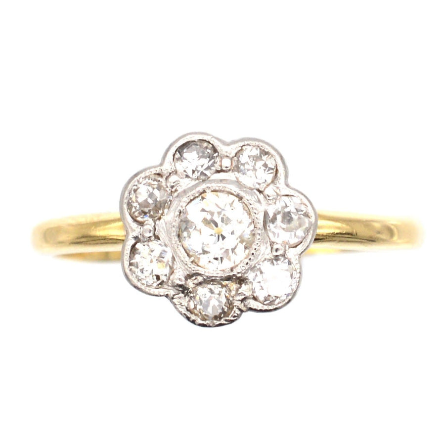 Art Deco 18ct gold and platinum diamond cluster ring featuring a central diamond and surrounding diamonds.