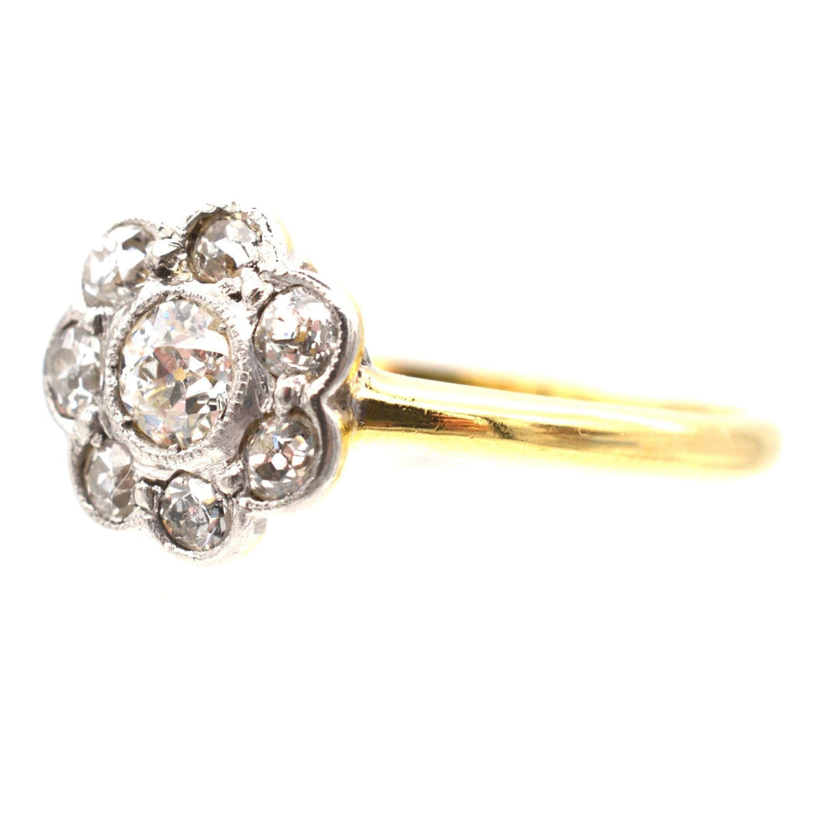 Art Deco 18ct gold and platinum diamond cluster ring featuring a central 0.20ct diamond and surrounding diamonds, perfect as an engagement ring.