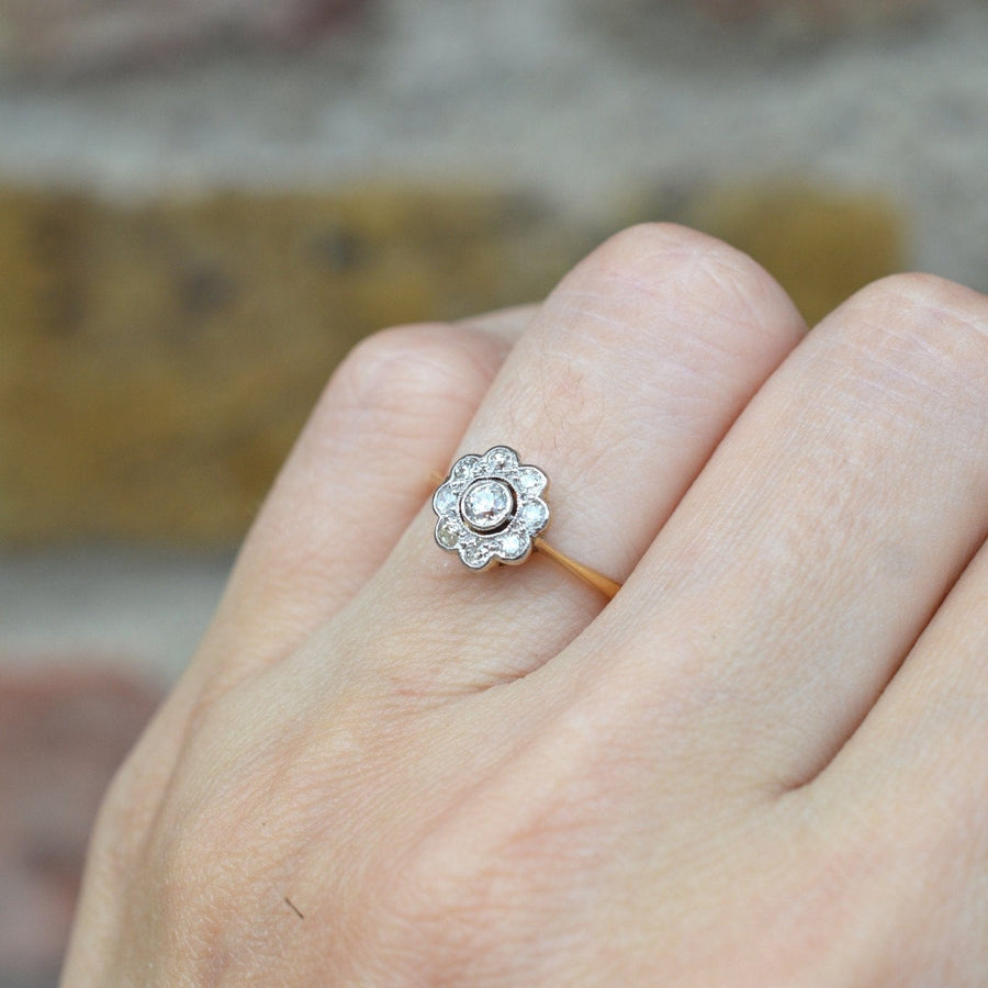 Art Deco 18ct gold and platinum diamond cluster ring with millegrain setting, circa 1920s, featuring central diamond.