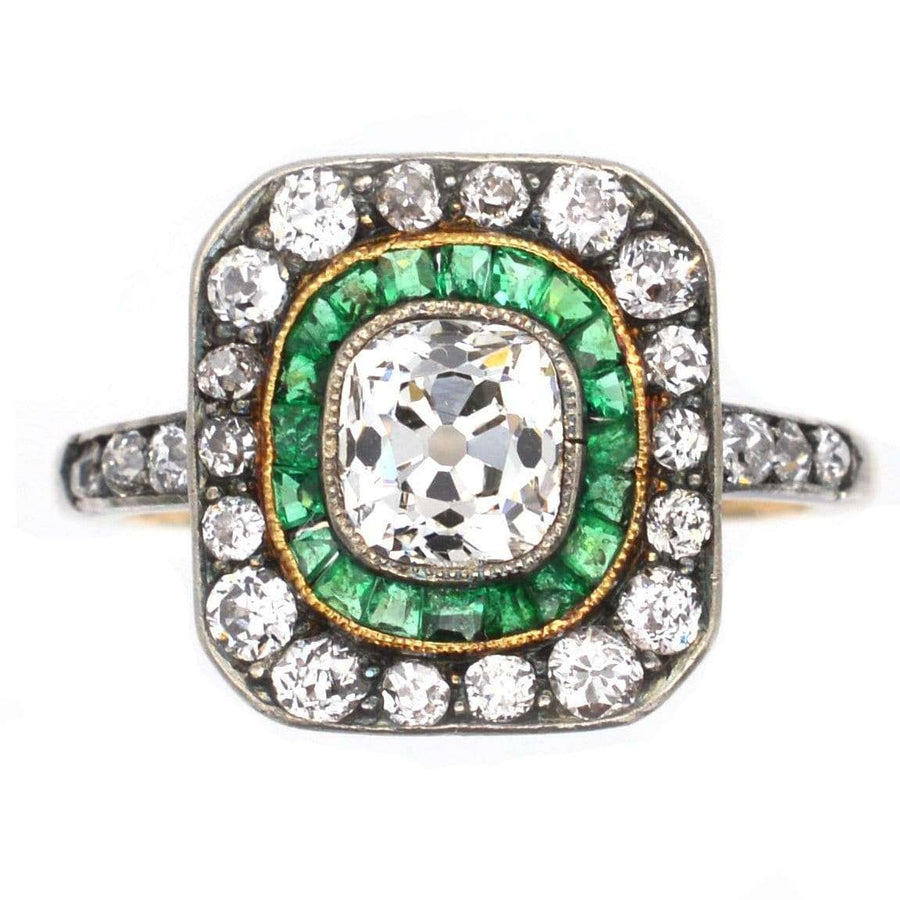 Art Deco 18ct Gold & Platinum ring featuring old mine cut diamond, emerald halo, and diamond accents.