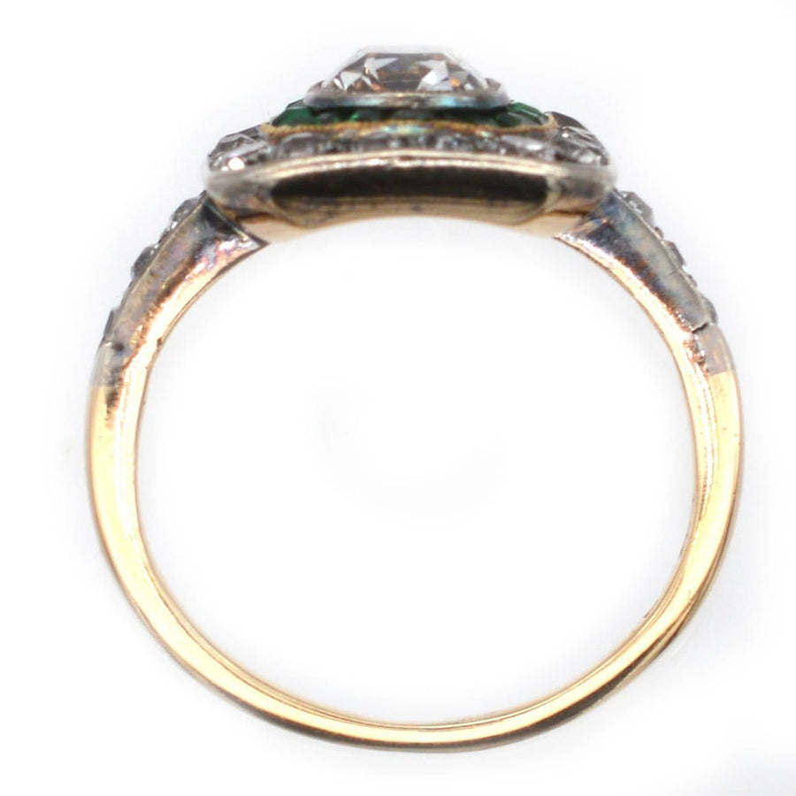 Art Deco 18ct gold and platinum ring featuring an old mine cut diamond, emeralds, and diamonds.