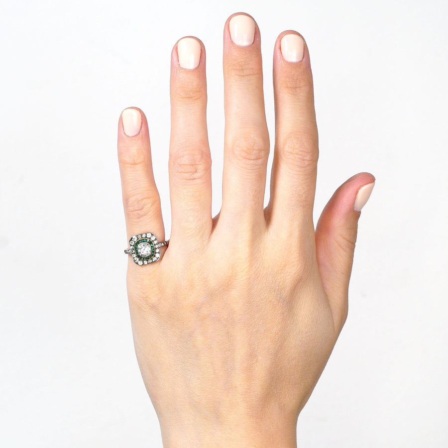 Beautiful Art Deco 18ct gold and platinum target ring with emeralds and diamonds, worn on a woman's hand.