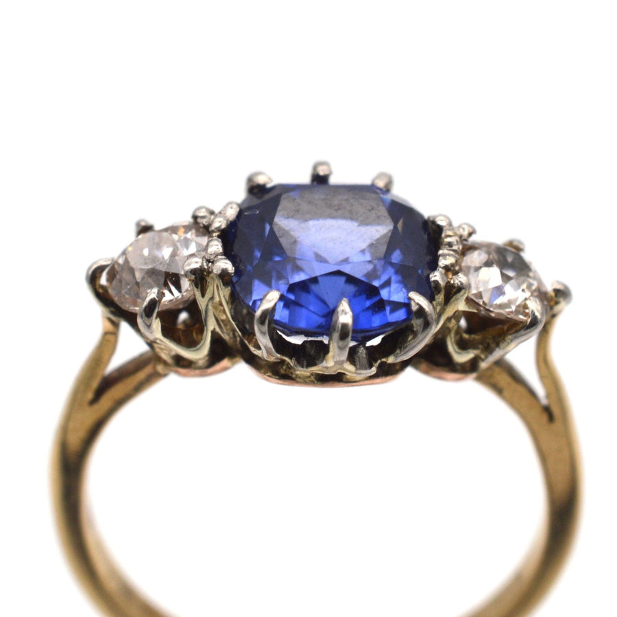 Art Deco 18ct gold and platinum three stone ring featuring a stunning sapphire and diamond accents.