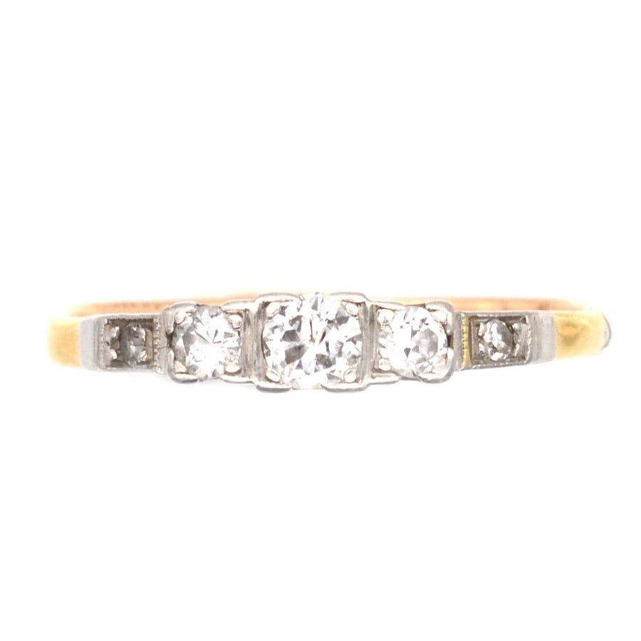 Art Deco 18ct gold and platinum three stone diamond ring with diamond shoulders, featuring an elegant design.