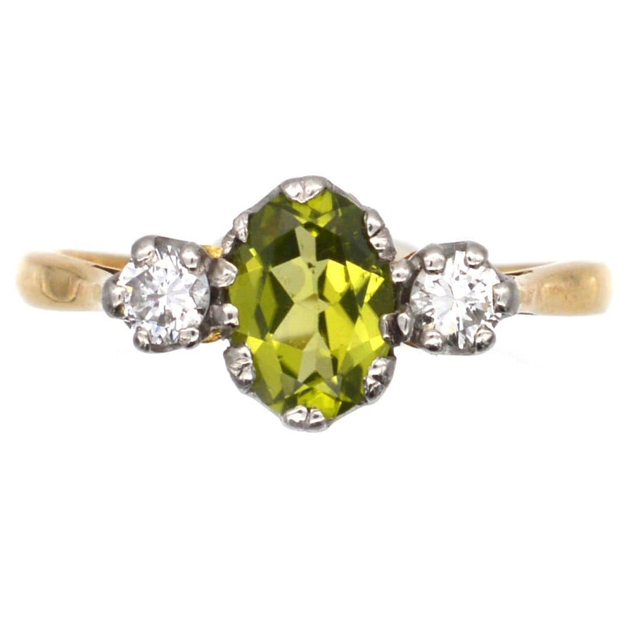 Art Deco 18ct gold and platinum three stone ring featuring a bright olive green peridot and two sparkling diamonds.
