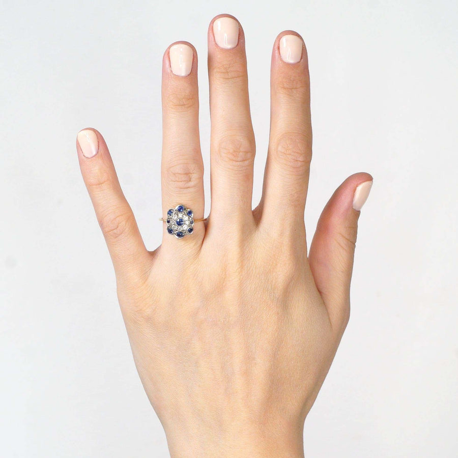 Art Deco 18ct gold ring featuring sapphires and diamonds, worn on a hand with manicured nails.