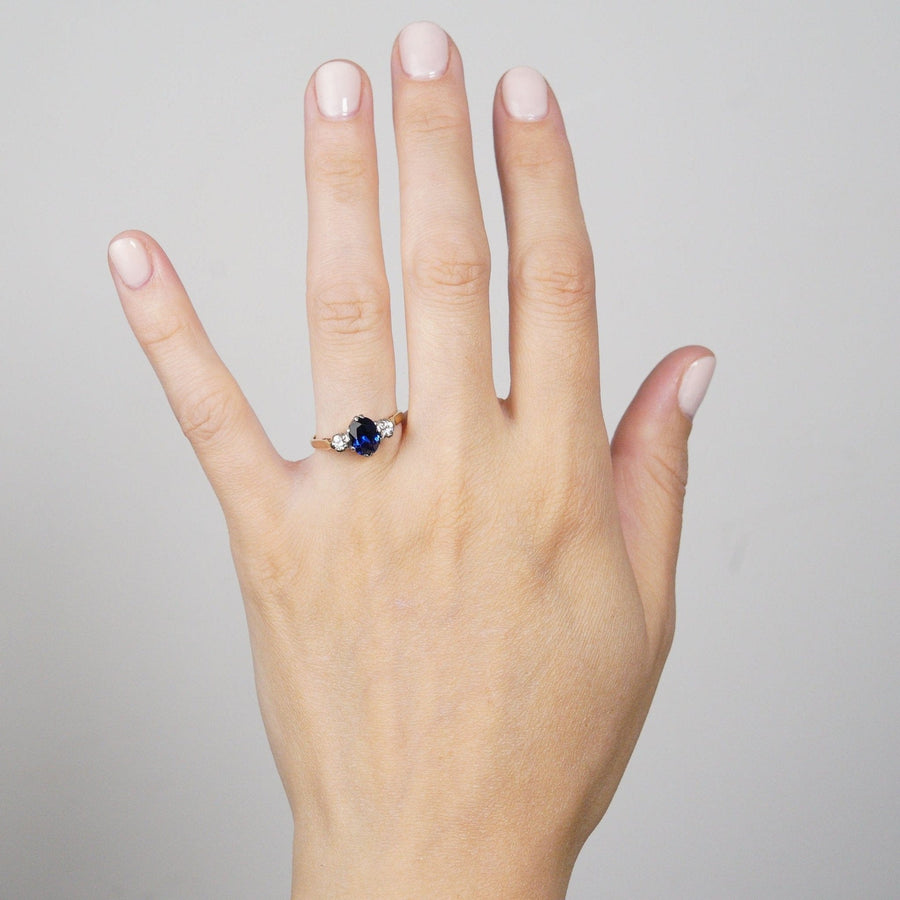 Art Deco 18ct gold sapphire and diamond three stone ring showcased on a hand.