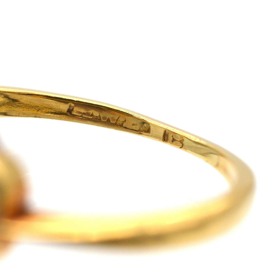 Close-up view of the interior engraving of a gold ring, showcasing the artisan's mark and craftsmanship.