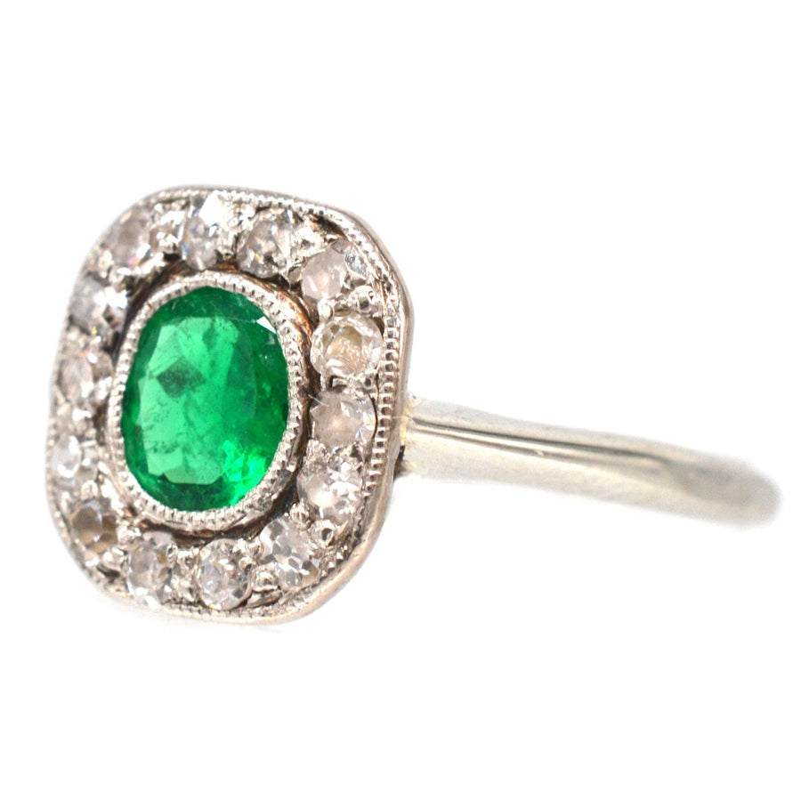 Art Deco 18ct white gold emerald and diamond cluster ring with vibrant emerald stone.