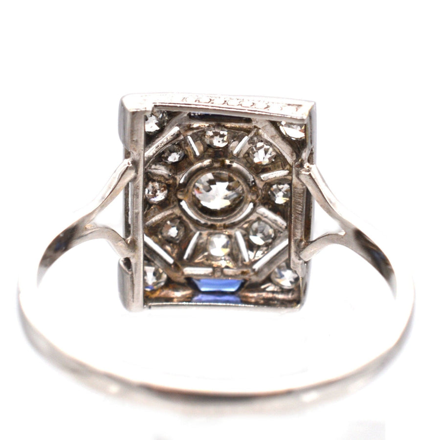 Art Deco 18ct white gold and platinum ring featuring diamonds and sapphires in a striking geometric design.