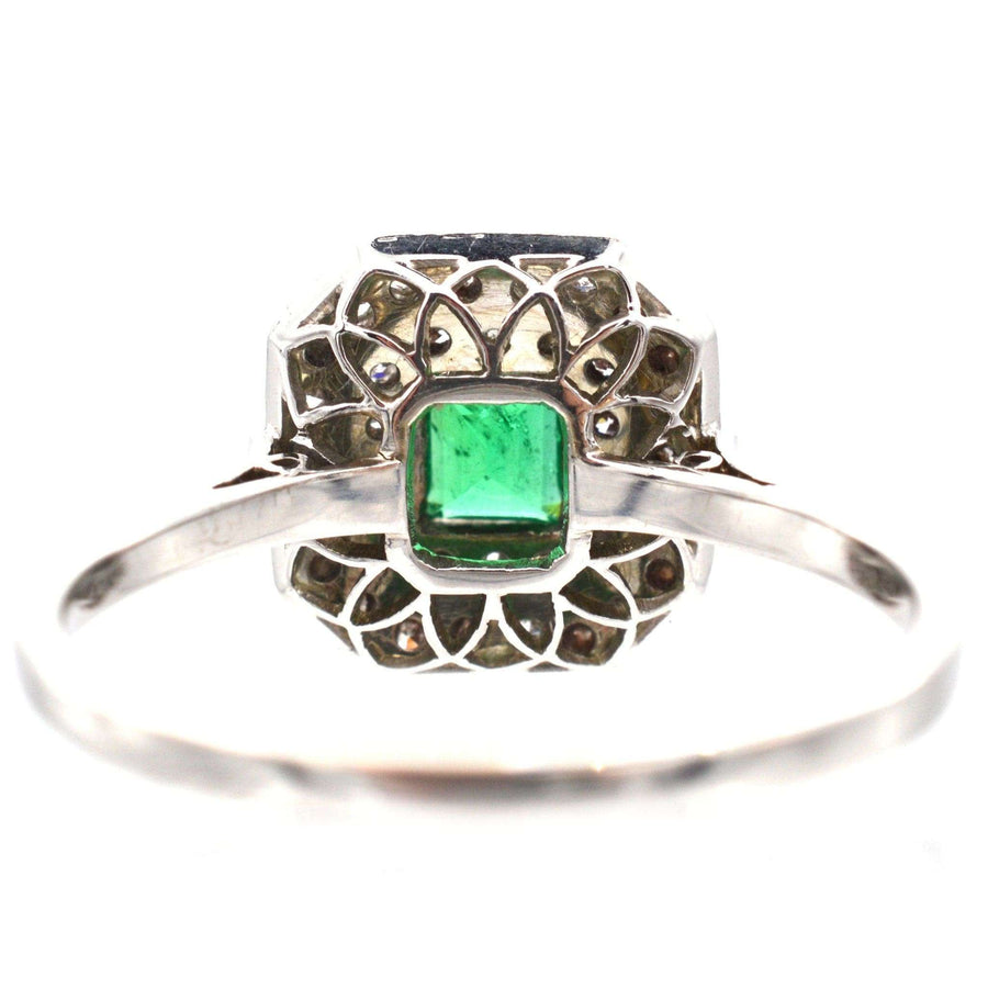Art Deco emerald and diamond cluster ring in white gold and platinum, circa 1920s, elegant and grand design.