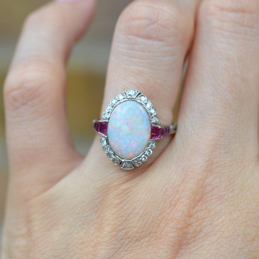 Art Deco ring in 18ct white gold and platinum, featuring an opal and Burma rubies, with diamond accents.