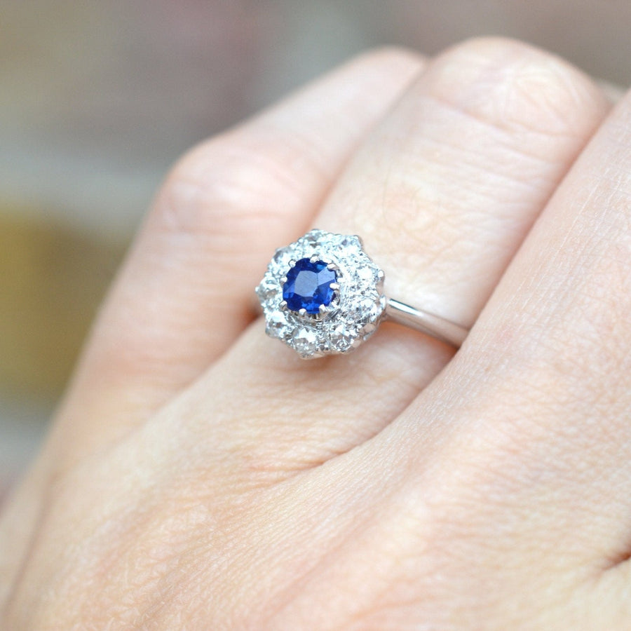 Art Deco 18ct white gold sapphire and diamond cluster ring showcasing a vibrant blue sapphire surrounded by sparkling diamonds.