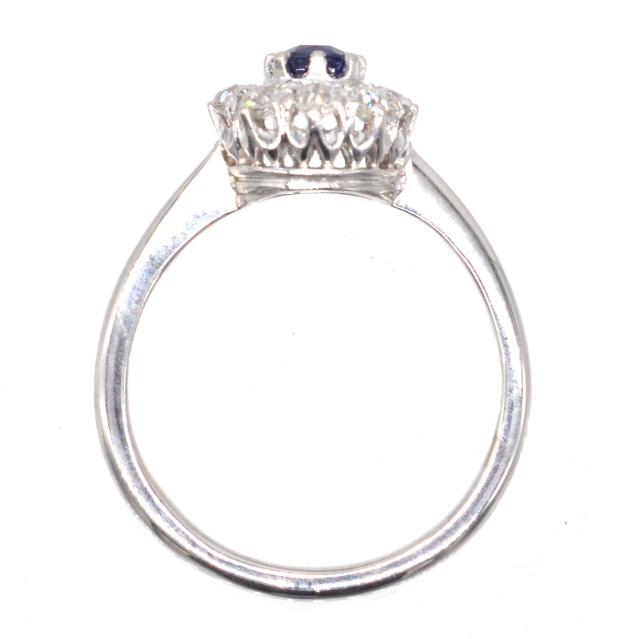 Art Deco 18ct white gold sapphire and diamond cluster ring, featuring a central sapphire and nine surrounding diamonds.