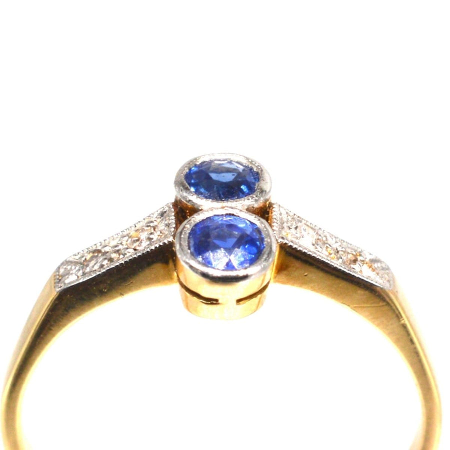 Art Deco platinum and gold sapphire and diamond ring with vibrant central sapphires and glittering diamond accents.
