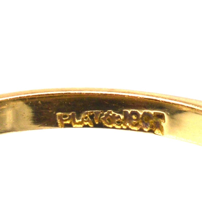 Close-up of the inner band of a ring featuring engraved 'PLAT' and '18CT' markings, showcasing gold and platinum composition.