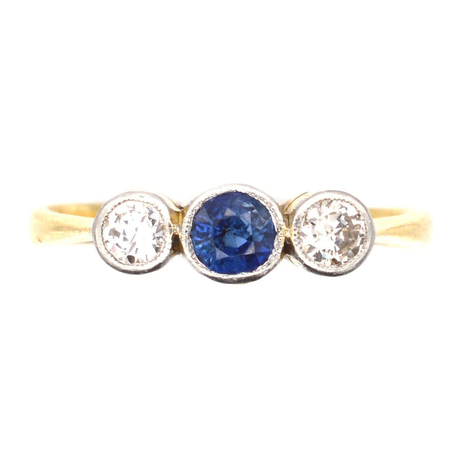 Art Deco platinum and 18ct gold three stone sapphire and diamond ring with vibrant blue center stone.