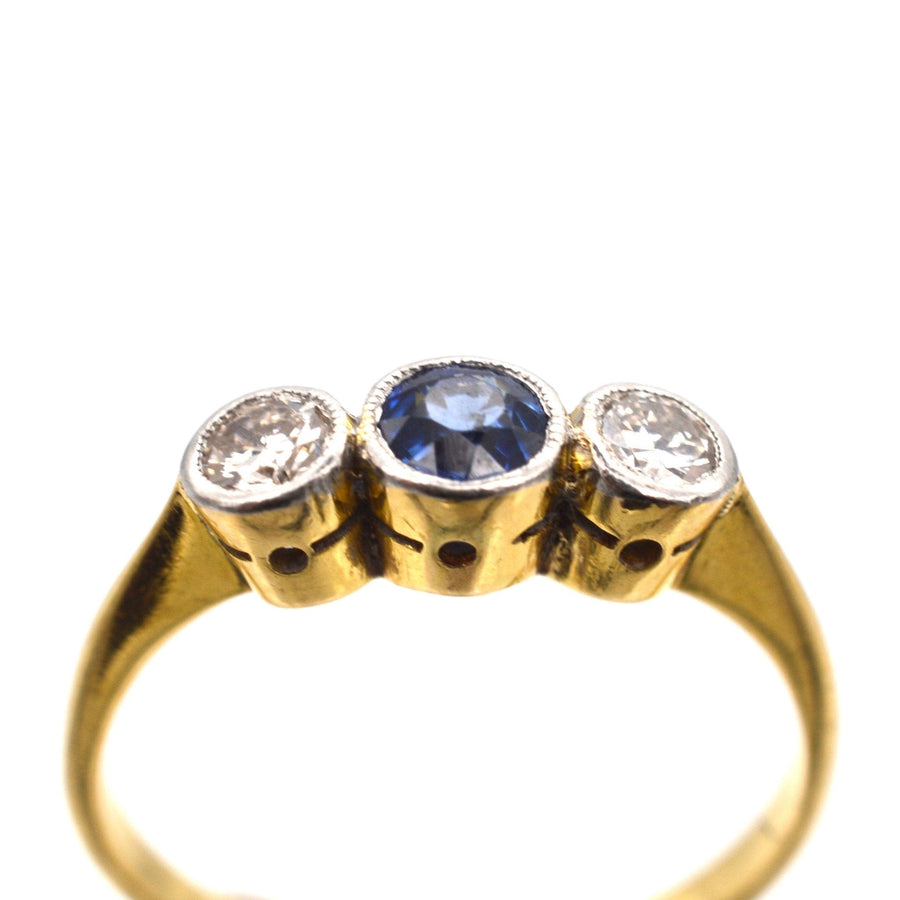 Art Deco three stone sapphire and diamond bezel ring in platinum and gold, ideal for engagement.