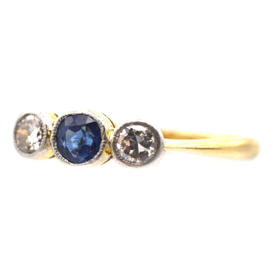 Art Deco three stone sapphire and diamond bezel ring in platinum and gold, ideal engagement ring.