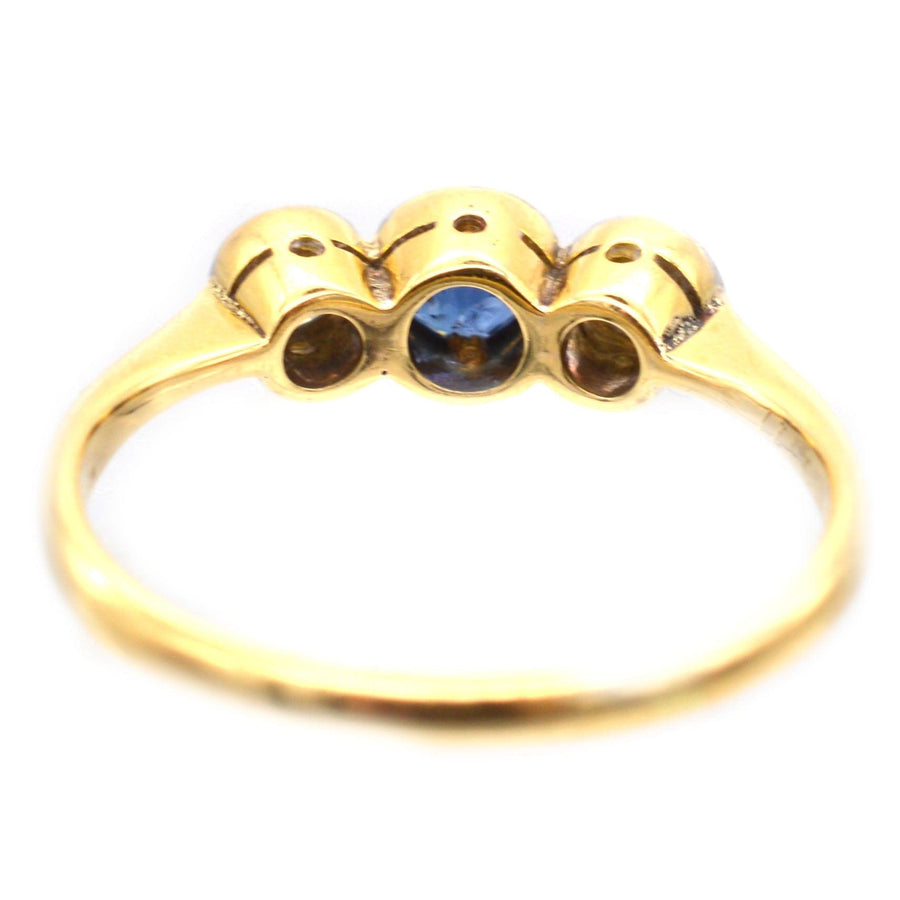 Art Deco platinum and 18ct gold three stone sapphire and diamond bezel ring in mid-blue.