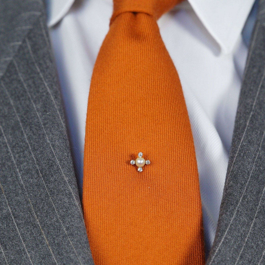 Edwardian 18ct gold tie pin featuring a natural pearl and four white diamonds, worn on an orange tie.